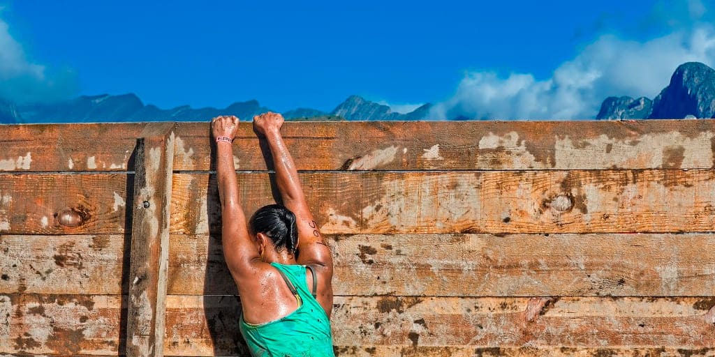 Mujer deportista agarrada a muro -Médico y coach