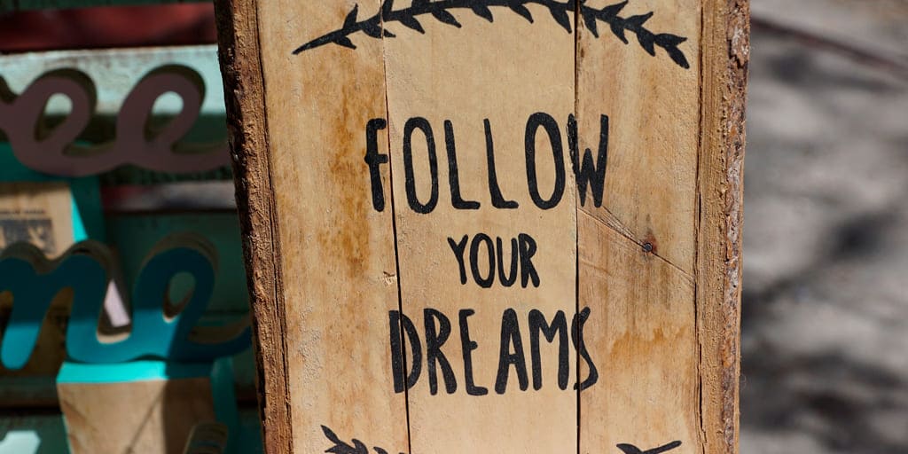 Foto de panel de madera con texto "Follow your dreams"